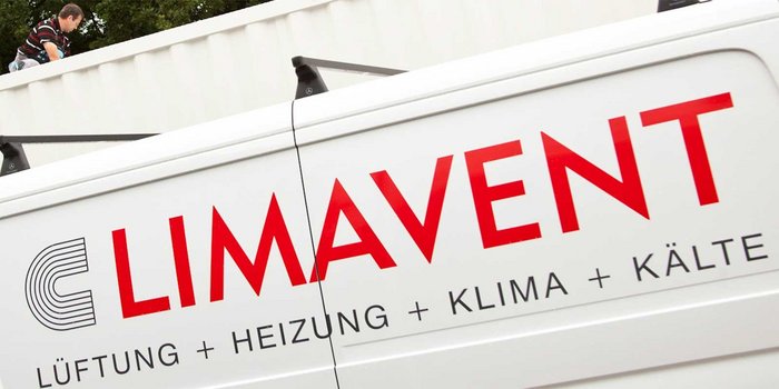 Ein Handwerker arbeitet auf einem Dach, während ein Fahrzeug mit dem Logo 'LIMAVENT' im Vordergrund steht.